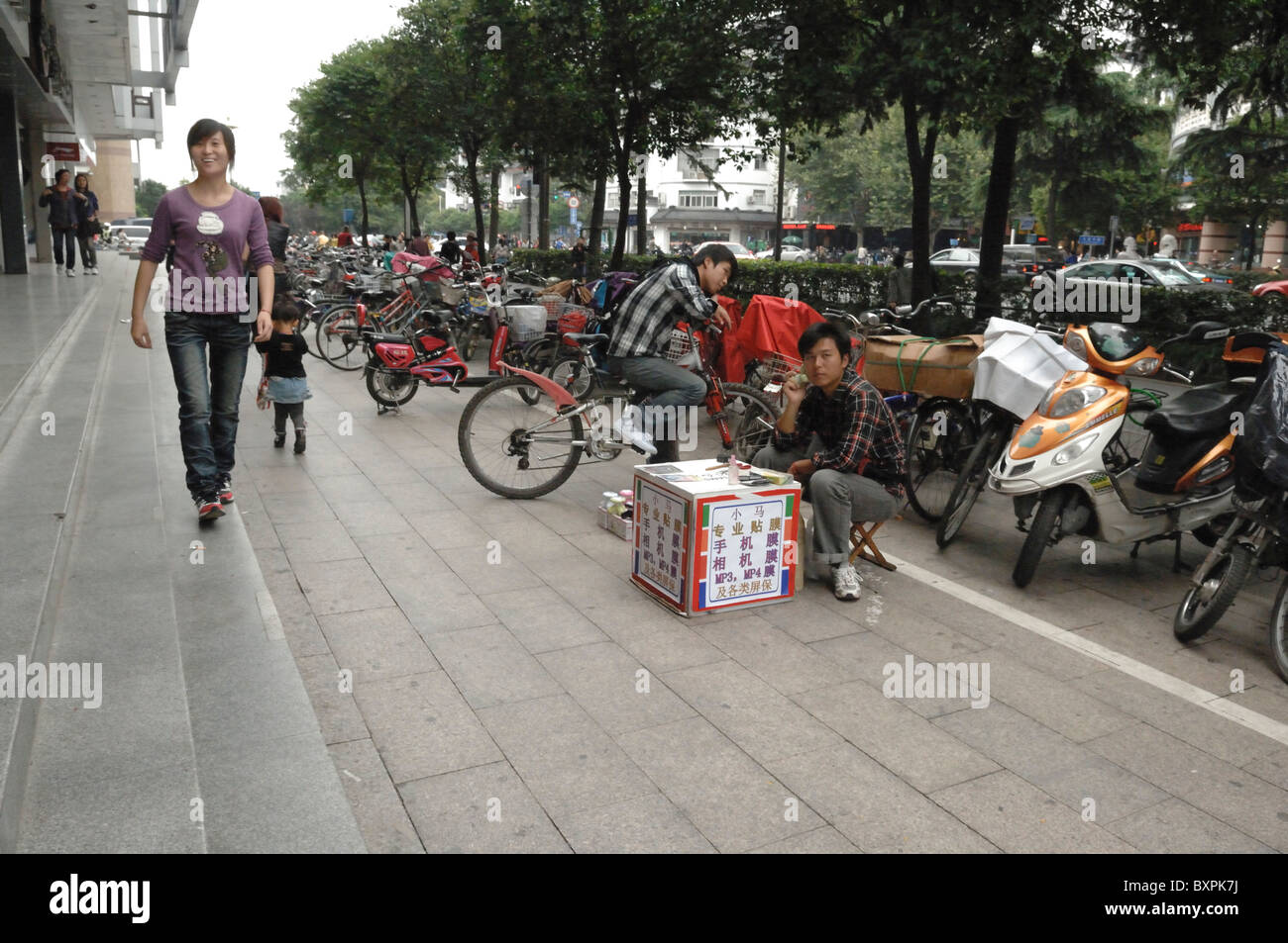 An urban street in with bikes parked and  a street seller Yangzhou China Stock Photo