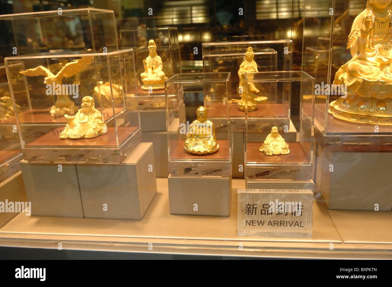 Different size Gold Buddhas for sale in a jewelery shop window in Yangzhou Jiangsu Province of China Stock Photo