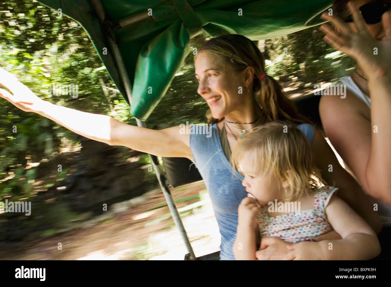 Mother With Daughter Waving Goodbye In Back Of Jeep Stock Photo