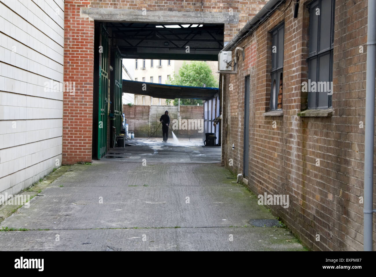 Man hosing down a car wash area; Bath Somerset Stock Photo Alamy