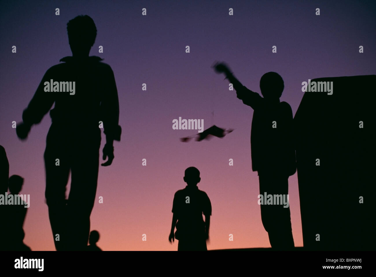 Silhouettes Of People Flying Kites Stock Photo