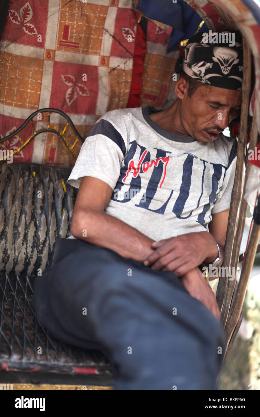 A rickshaw driver sleeps in Kathmandu, Nepal in Asia Stock Photo