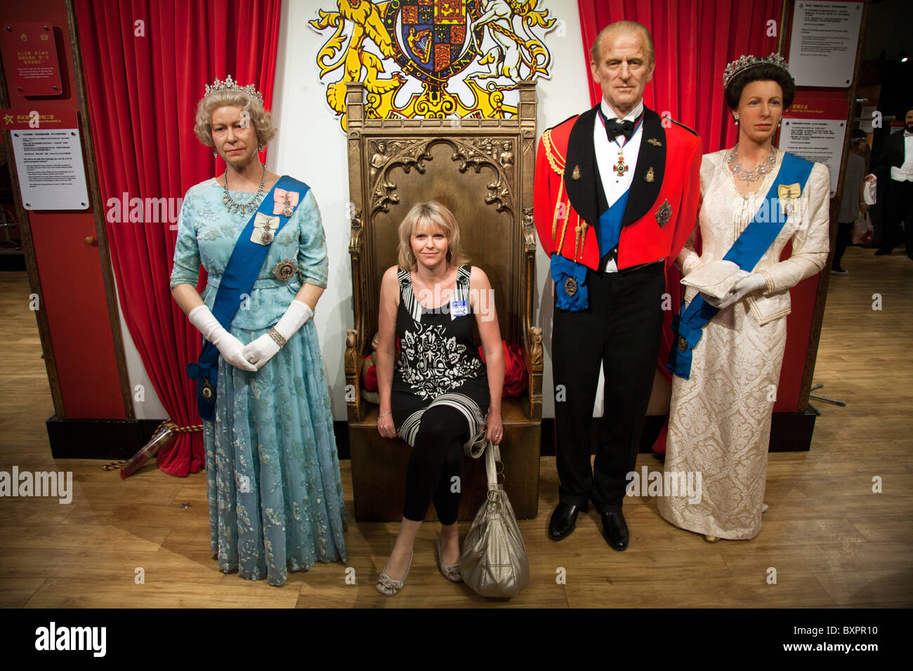 Madame Tussauds Hong Kong at Victoria Peak  featuring lady posing with the Queen of England & Prince Phillip Stock Photo