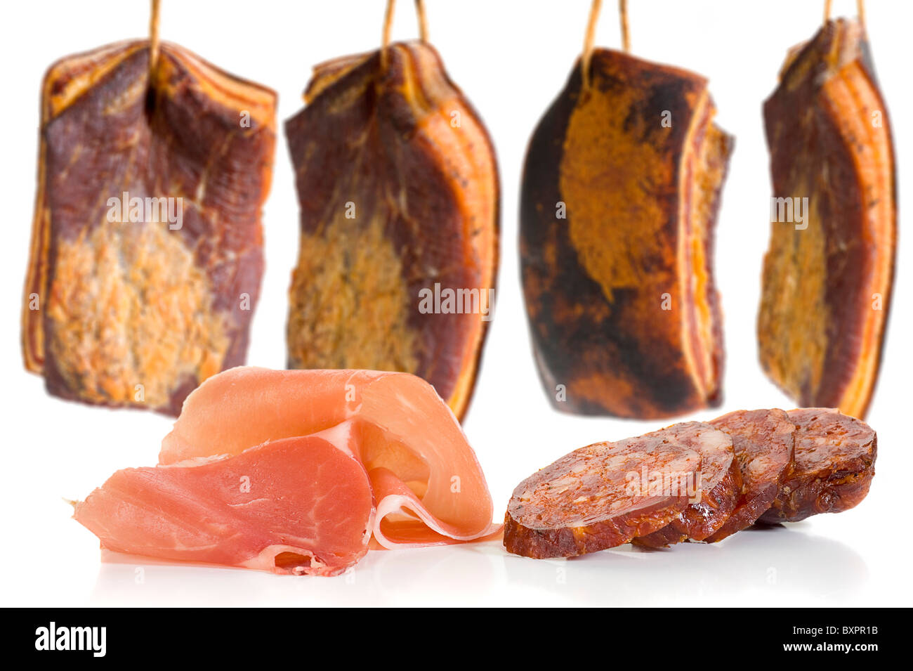 Slice of prosciutto and salami with bacon in background Stock Photo