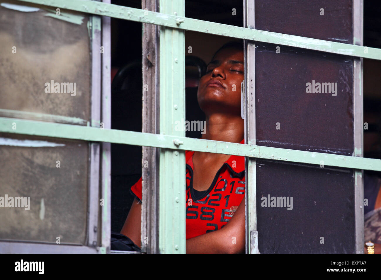 Indian female seated beside by bus window asleep with eyes closed, Calcutta, India Stock Photo