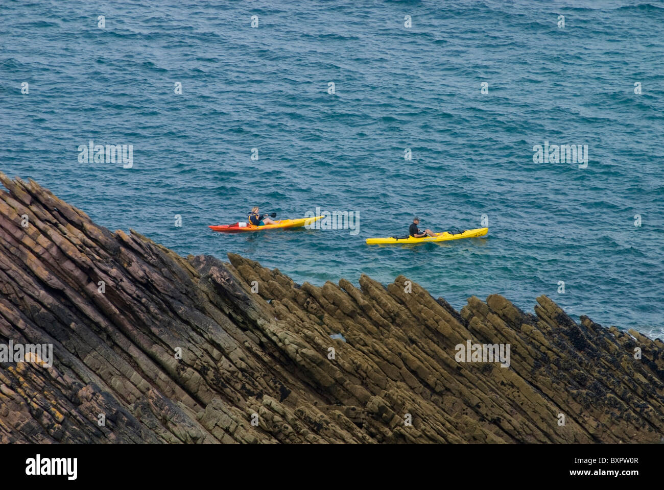 Couple Sea Kayaking Past Rocks Near Erquy Stock Photo - Alamy