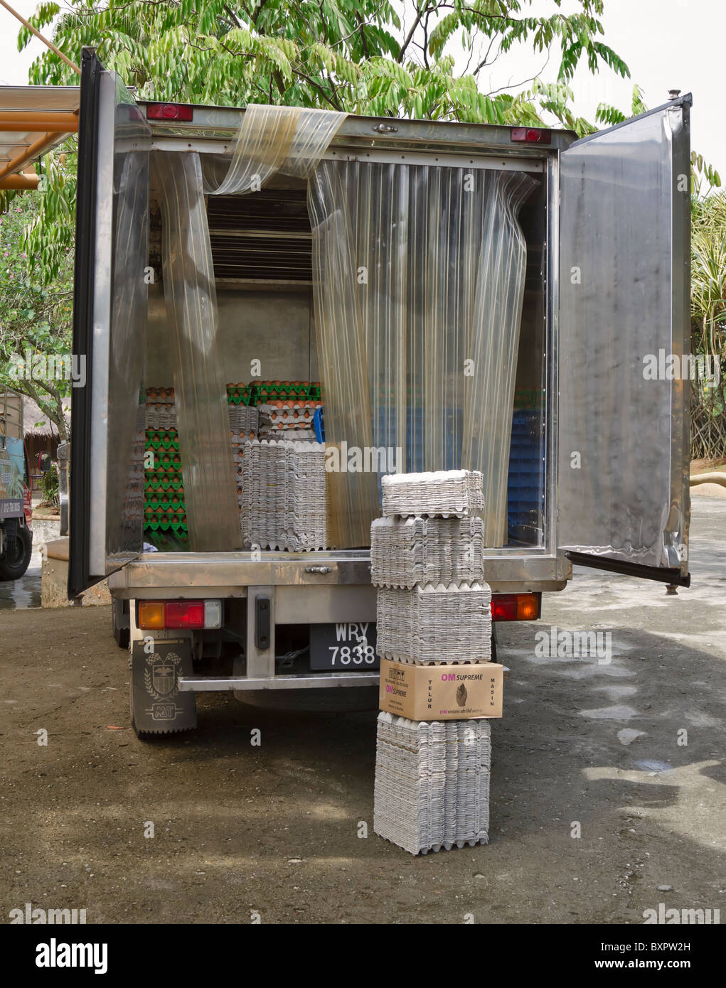 Eggs in the back of a delivery truck. Brown eggs in paper and plastic trays are stacked in the back of the lorry Stock Photo