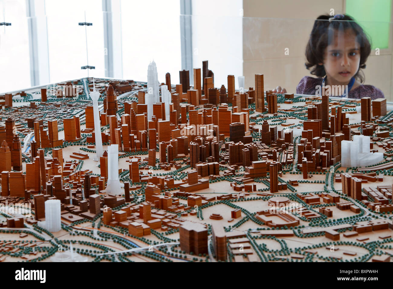 Architectural model of Kuala Lumpur, Malaysia. A child looks at the