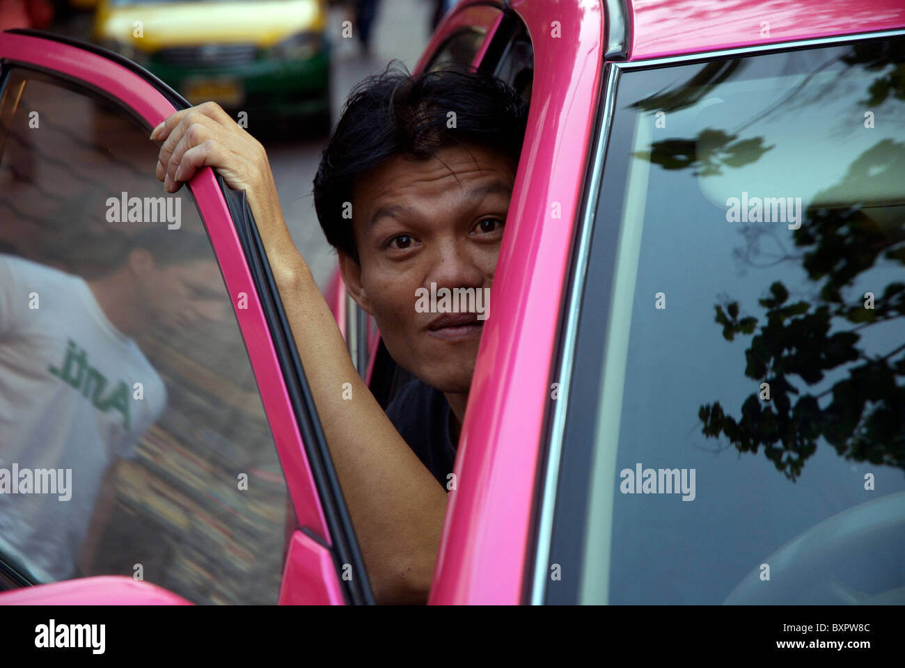 Taxi driver in Bangkok looks out of the Taxi Stock Photo