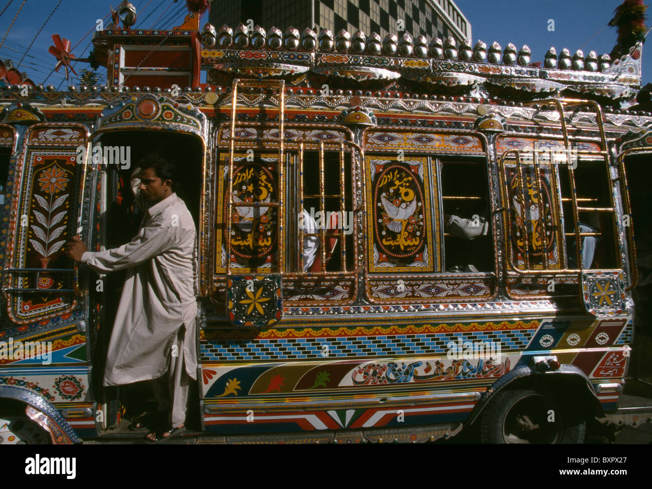 A multi-colored bus moves on the streets of downtown Karachi, Pakistan. Stock Photo