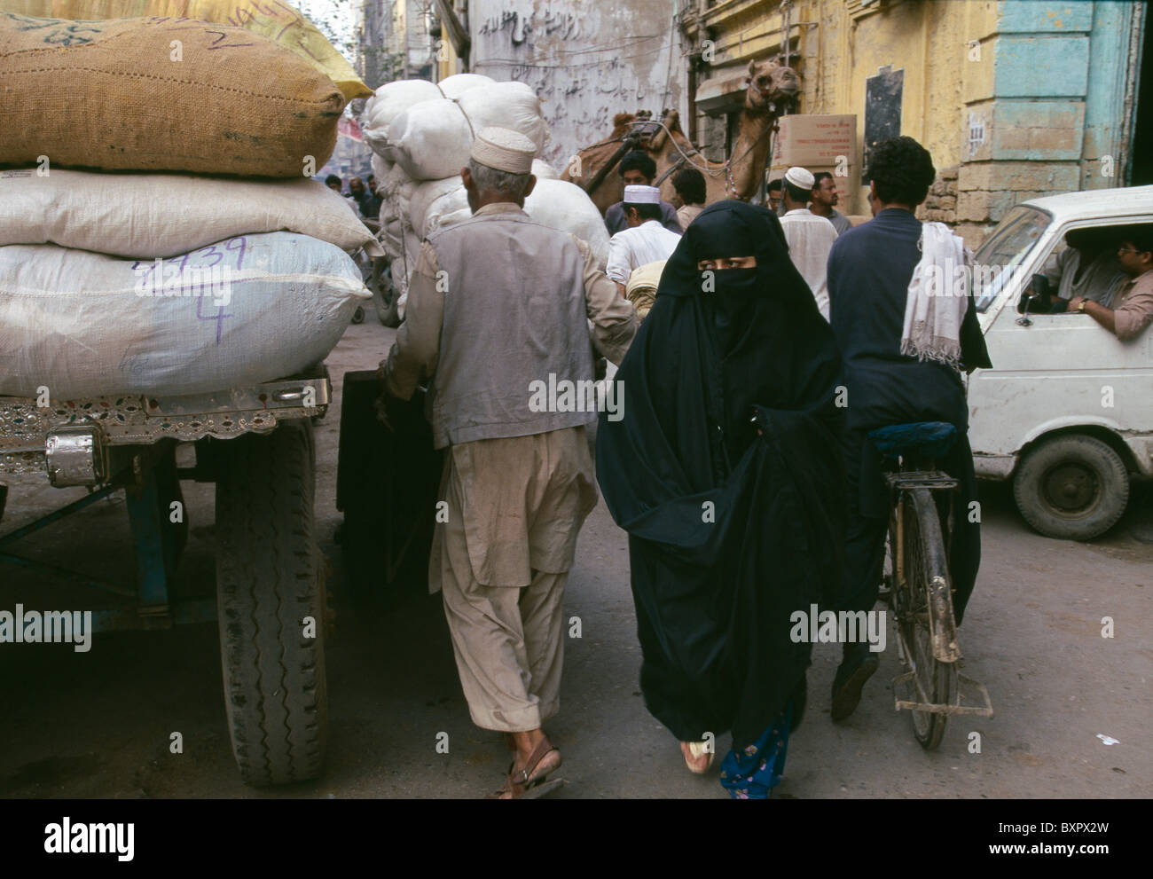 A veiled Muslim woman walks through the market area of Karachi, Pakistan. Stock Photo