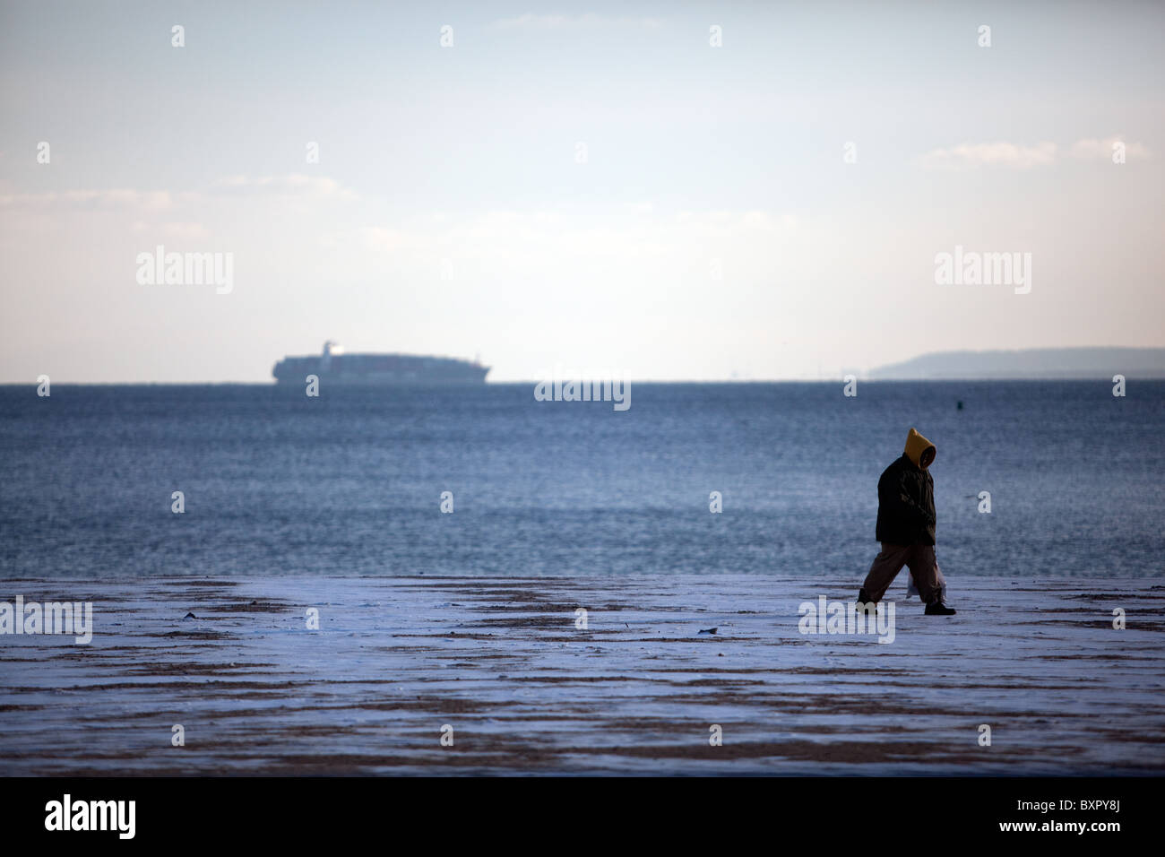 Man walking on the beach a cold day. cold weather Stock Photo