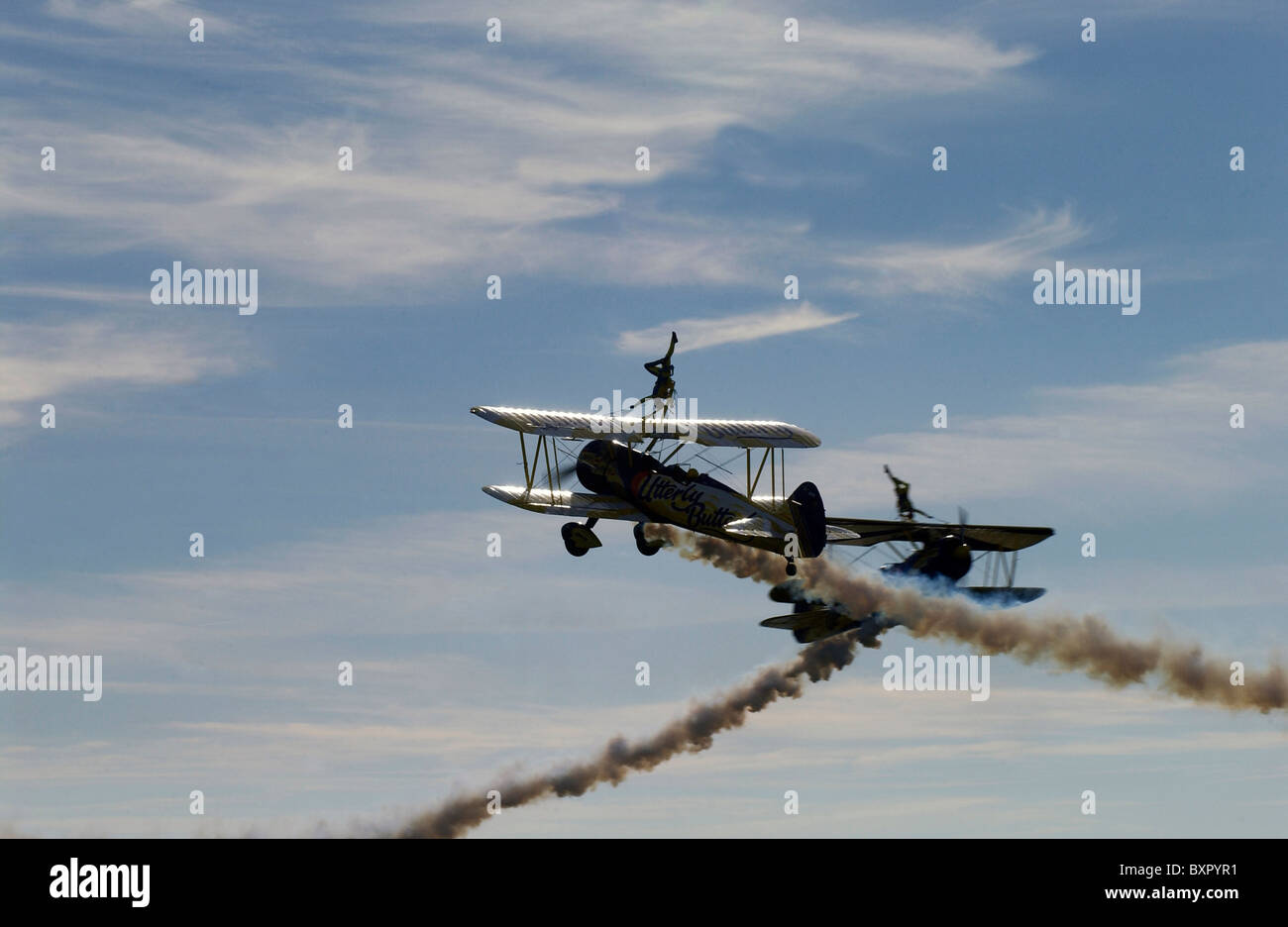 Two stunt biplanes with two wing-walking stunt performers (both girls) at an airshow. Stock Photo