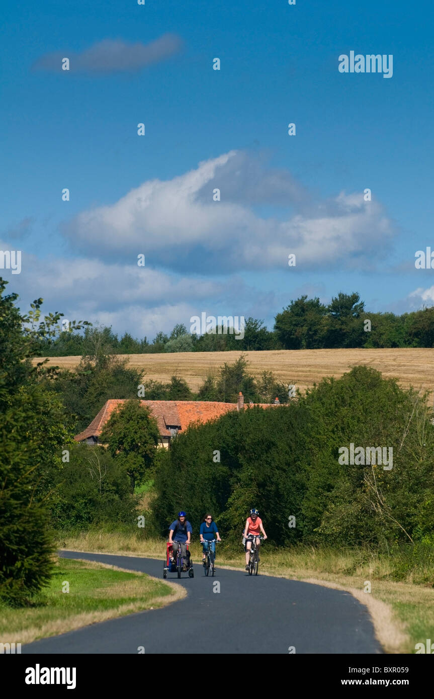 People Cycling Along Country Road Stock Photo