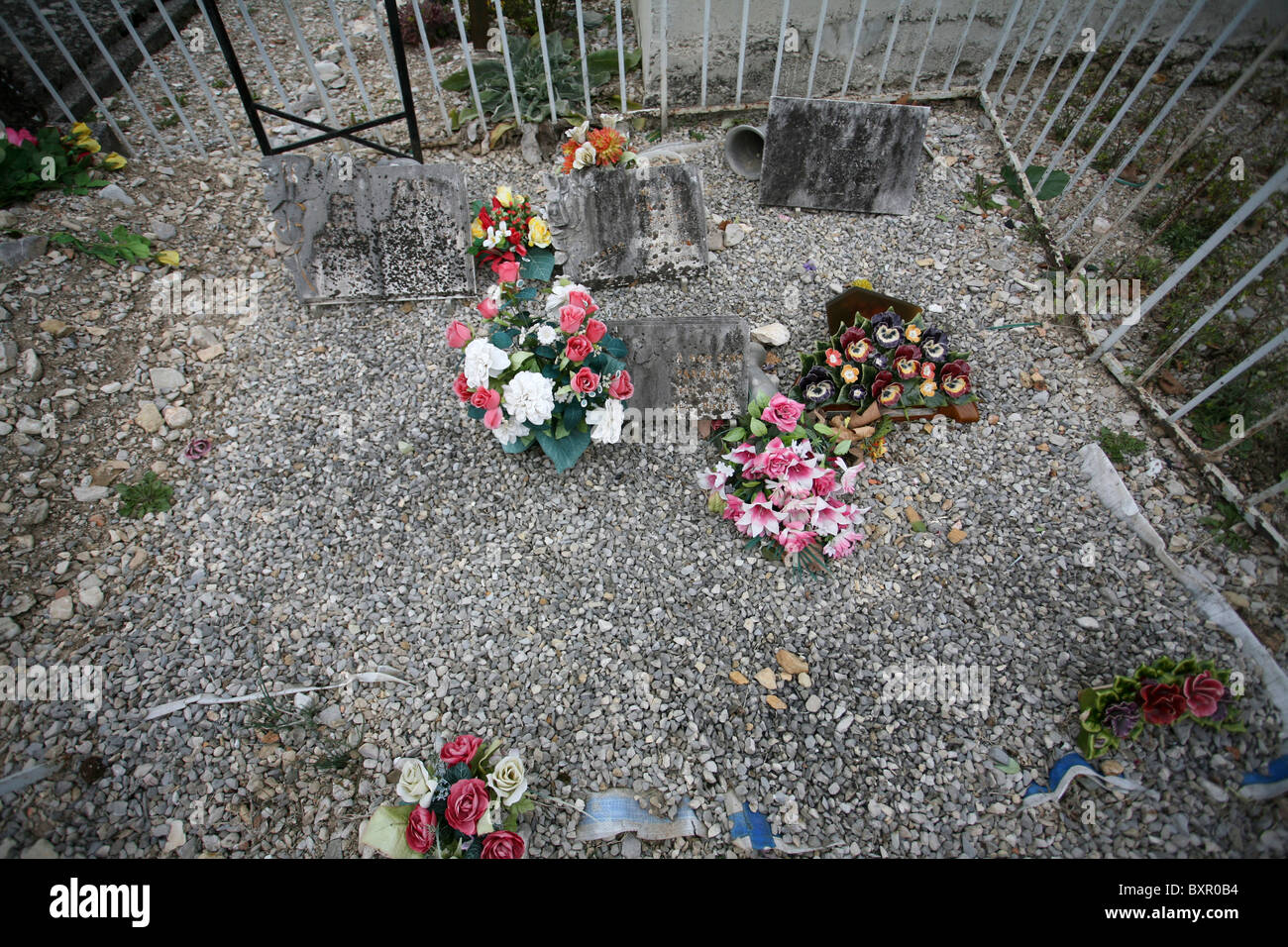 Artificial flowers and ornaments on a grave site in the Cimetière de Die, South-East France. Stock Photo