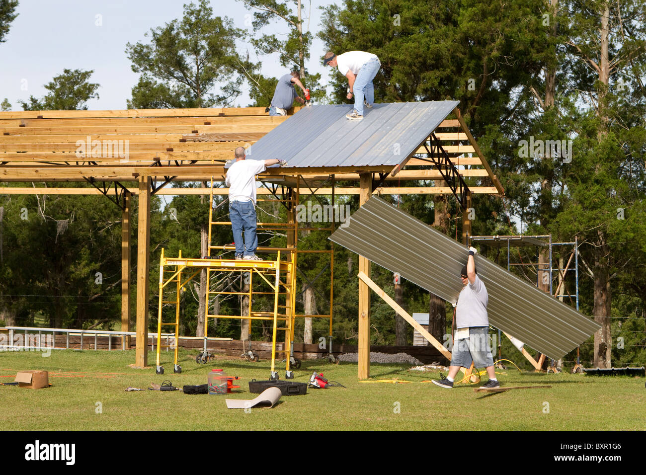 Four Construction Workers Apply Corrugated Metal Sheets To The