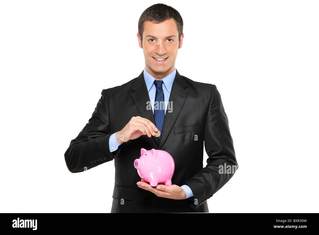A businessman putting a coin into a piggy bank Stock Photo - Alamy