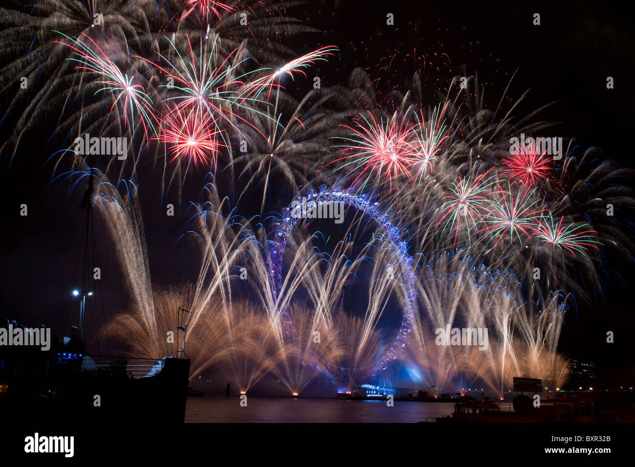 The London Eye lit up by fireworks on New Years eve 31st December 2010 ...