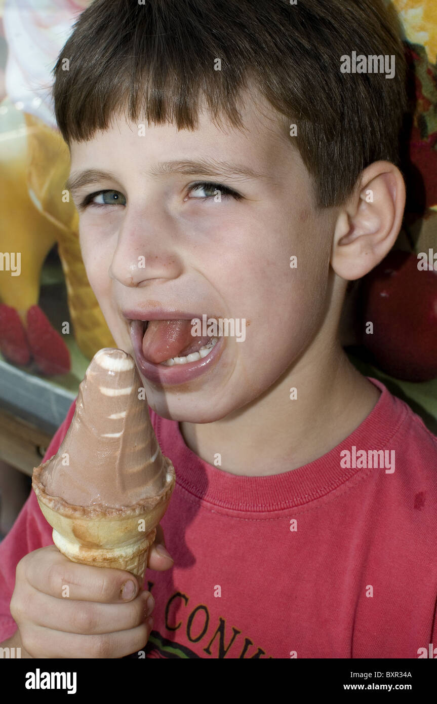 young boy eating ice cream cone mouth open child Stock Photo Alamy