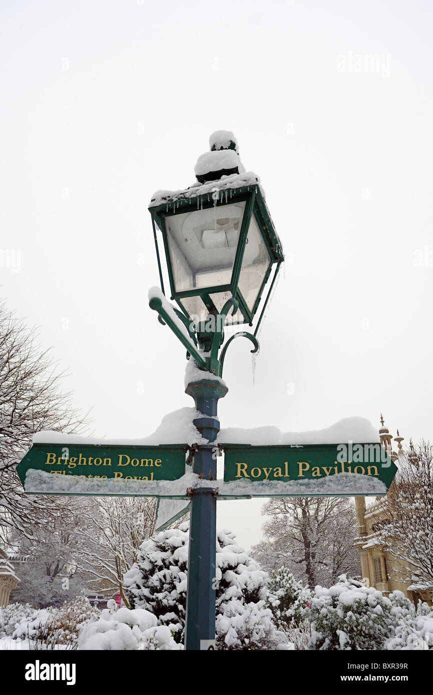 Old street lamp with sign showing directions covered in snow Stock ...
