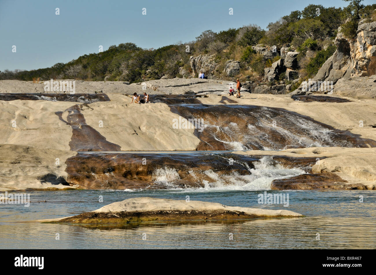 Visitors enjoying falls in paleozoic rocks exposed in Pedernales Falls ...