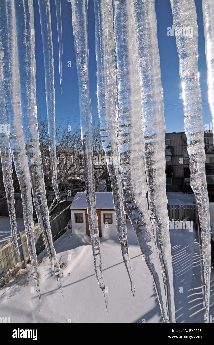 Icicles form outside a window depicting winter in Canada. Stock Photo