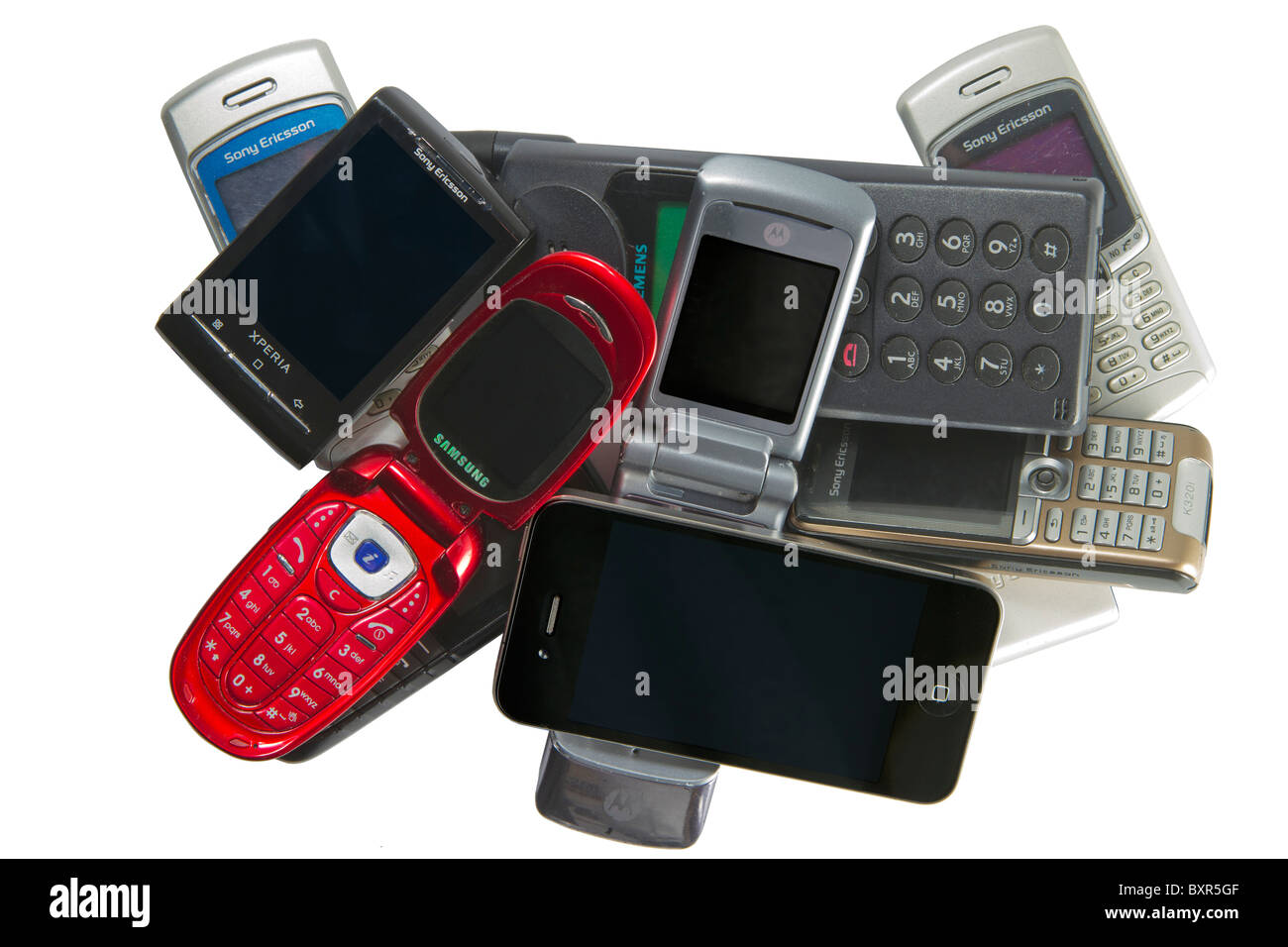 Pile of old and new mobile phones, including the Apple iPhone 4 and the Android phone Sony Ericsson Xperia X10 mini. Stock Photo