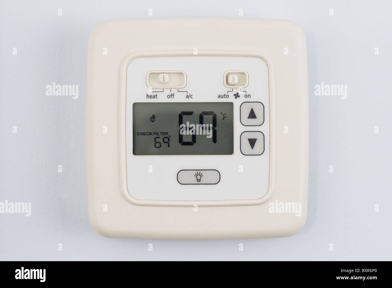digital thermostat on light blue wall set to heating 69 degrees F Stock Photo
