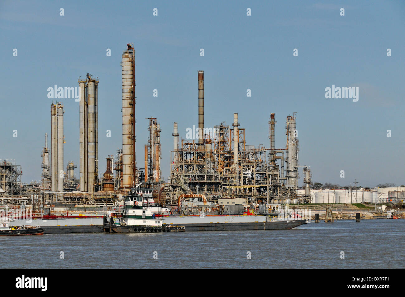 Barges unloading at Chevron oil refinery (largest refinery in US), Mississippi River, New Orleans, Louisiana Stock Photo