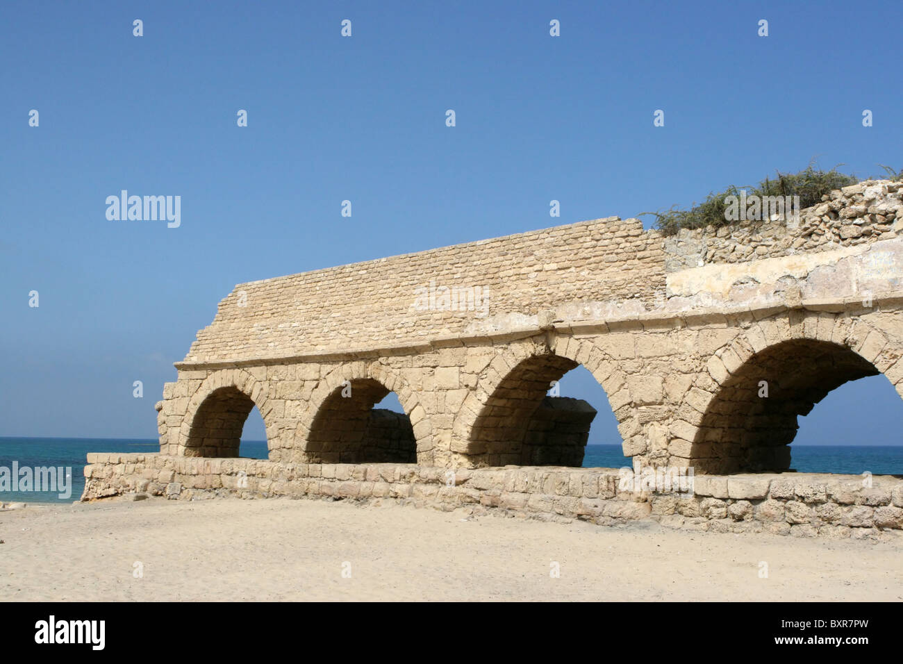 Ruins of an ancient Roman aqueduct were build by the Mediterranean Sea. They were used to transport water from distant mountains Stock Photo