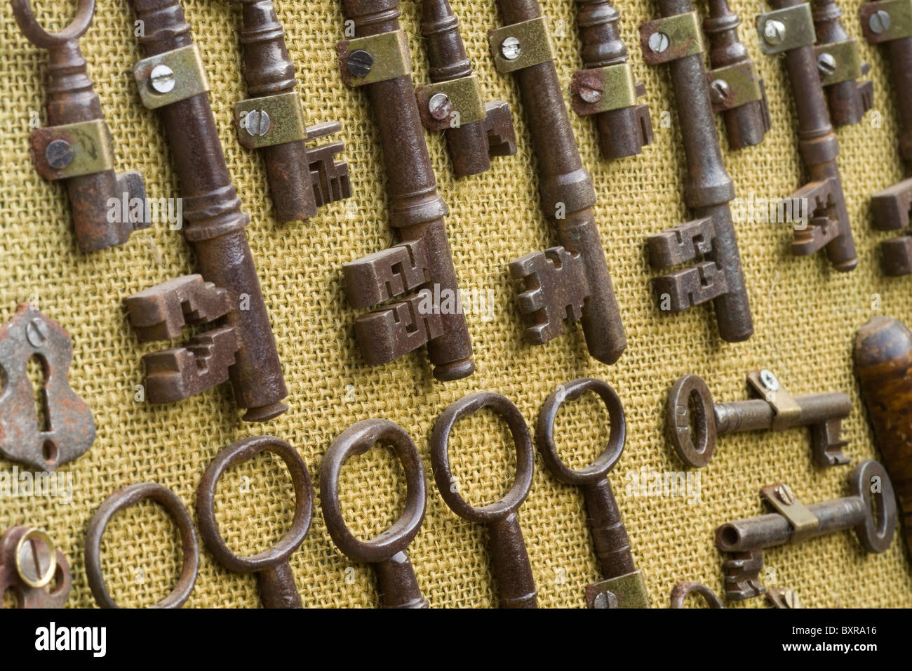 A close up of some of the keys and other objects on a locksmiths display board Stock Photo