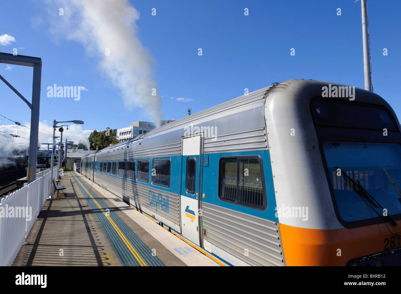 Diesel train producing a plume of smoke before departure from the station platform. Diesel multiple unit; emissions; exhaust fumes; passenger train Stock Photo