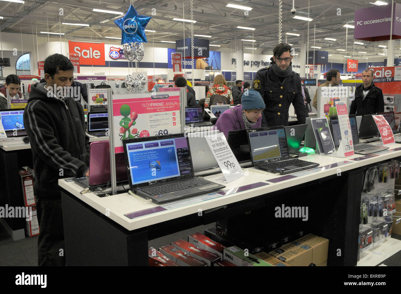 UK. SHOPPERS CHOOSING COMPUTER LAPTOP AT ELECTRONIC CONSUMER GOODS DEPARTMENT STORE DURING SALES