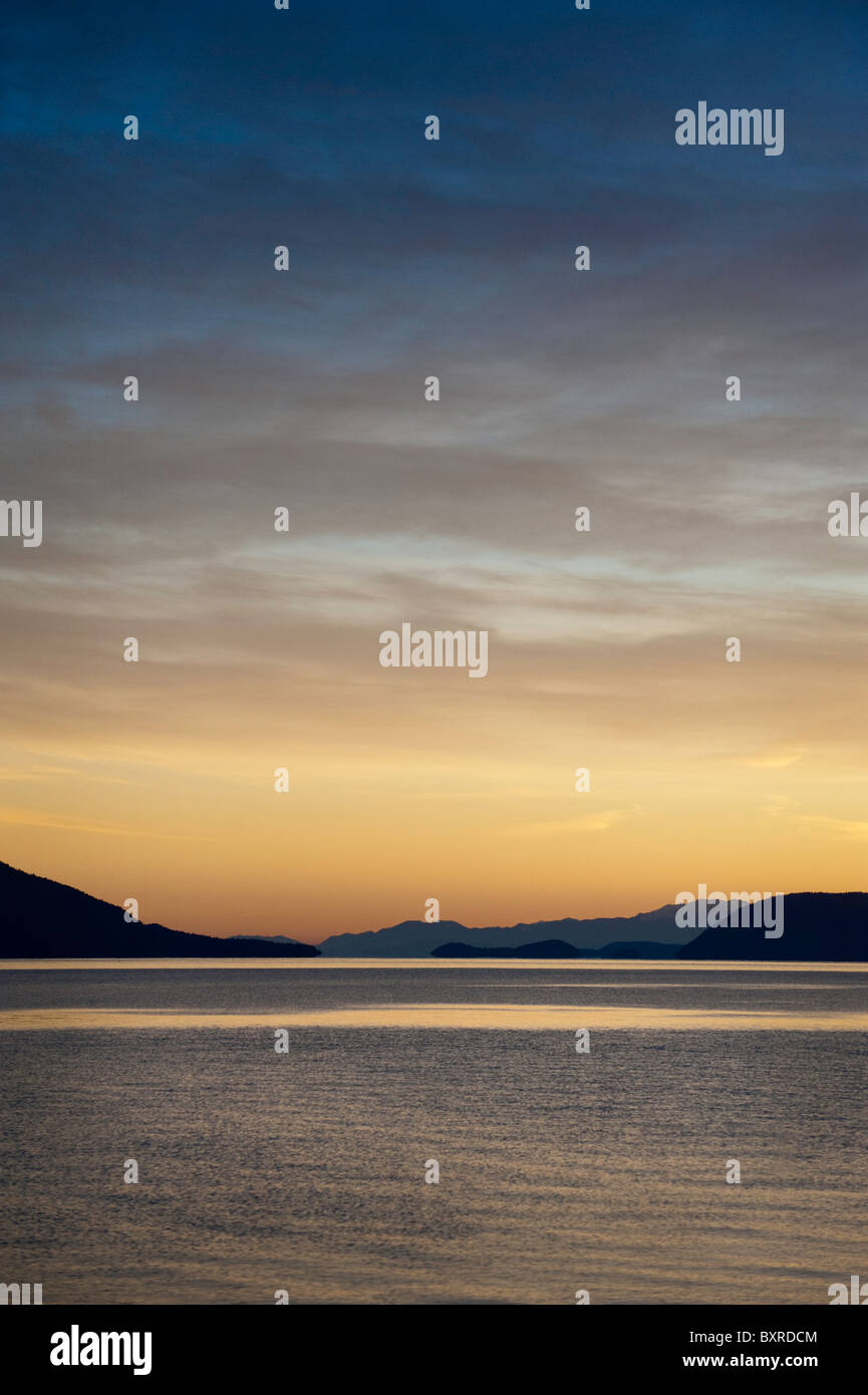 A beautiful sunset looking across Rosario Strait toward Orcas Island in ...