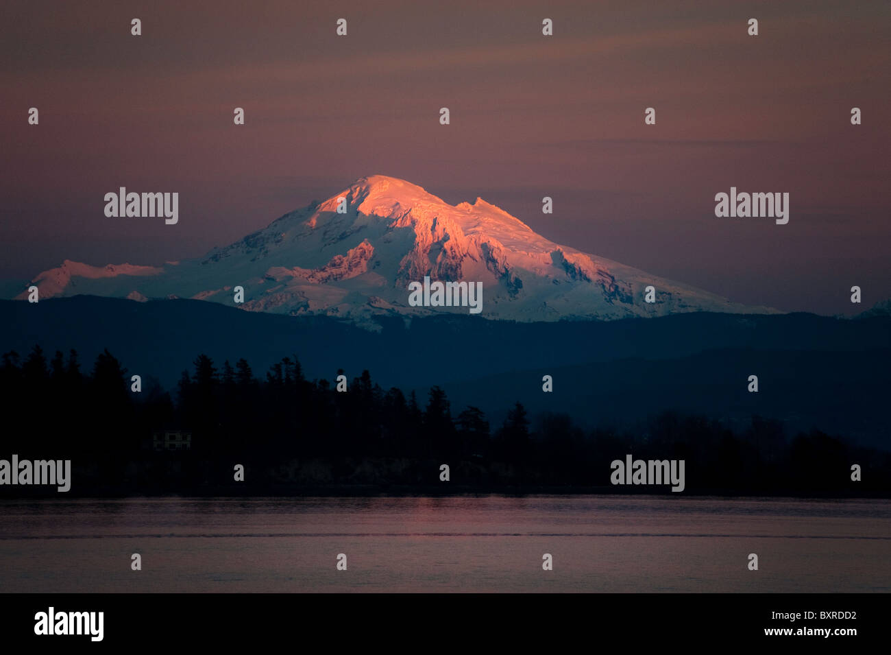 Mt. Baker, in Washington State, is awash in alpenglow after a spectacular sunset in the San Juan Islands. Stock Photo
