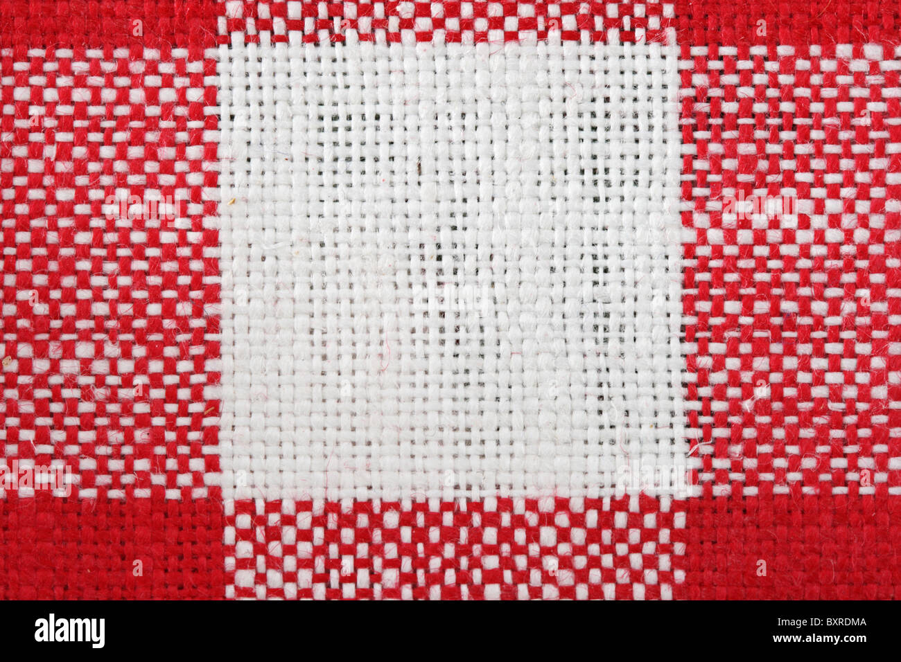 red and white tablecloth macro with a single white square and the surrounding red areas Stock Photo