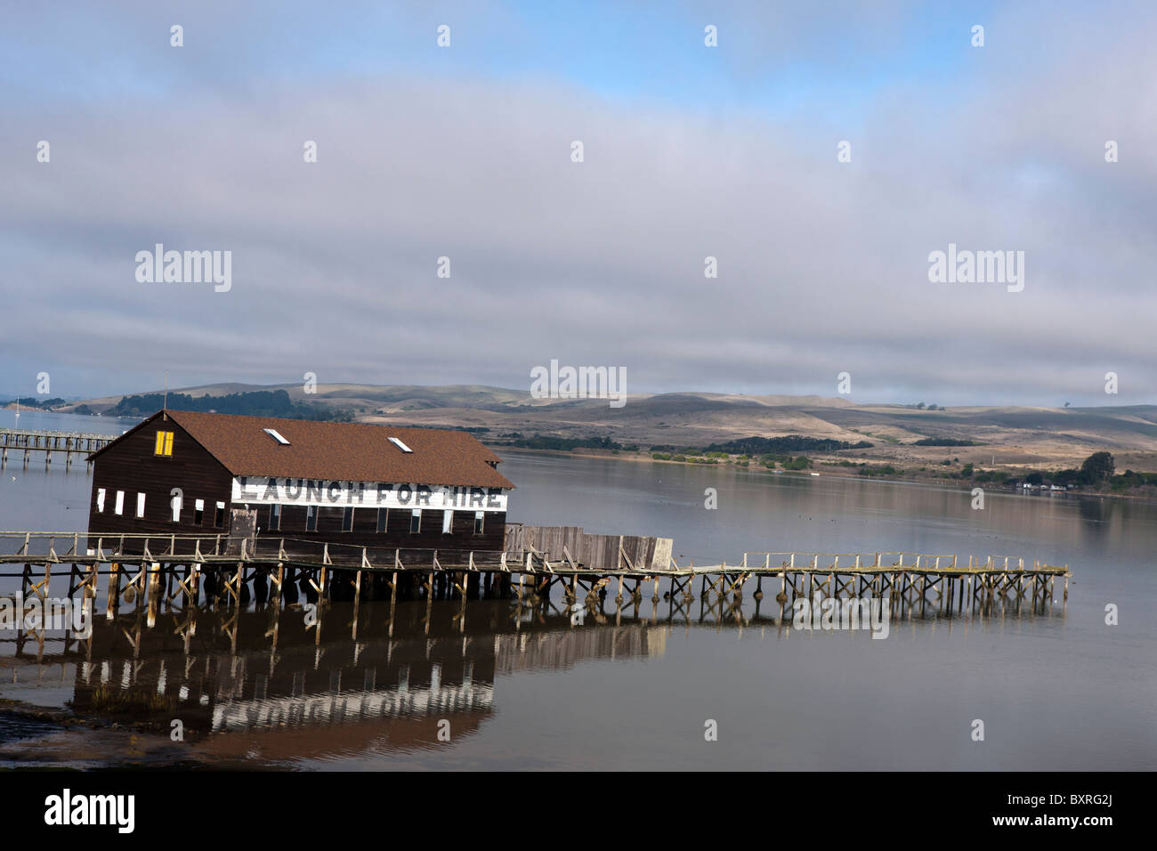 Boat house and pier with launch for hire advertising along the shore of
