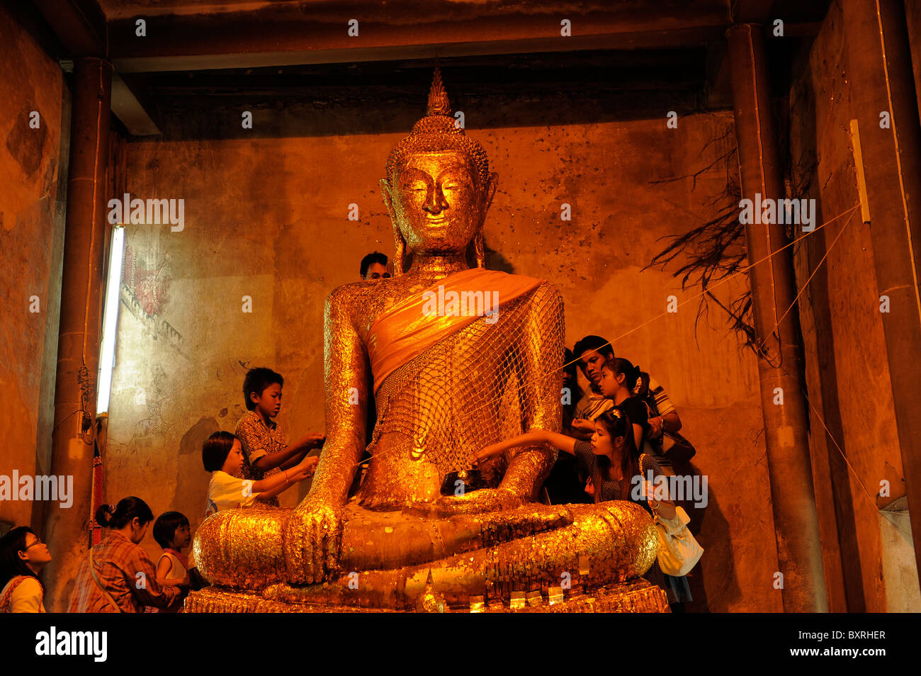 people placing gold leaves  on buddha statue , Wat Bang Kung in Amphawa district, Samut Songkhram , thailand Stock Photo