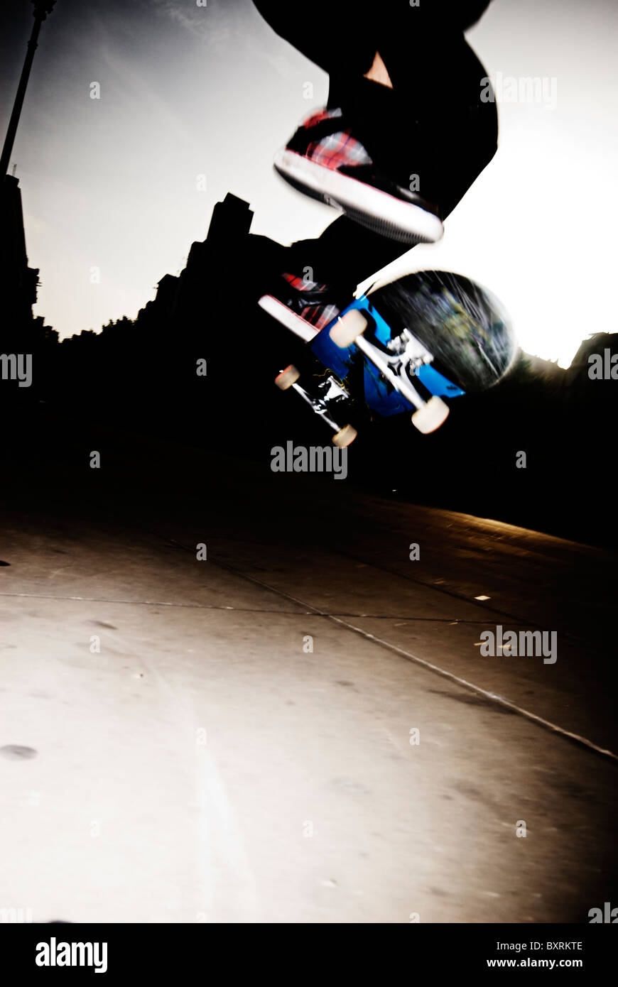 skateboarder doing a ollie flip at barcelona, with hard backlighting. Stock Photo