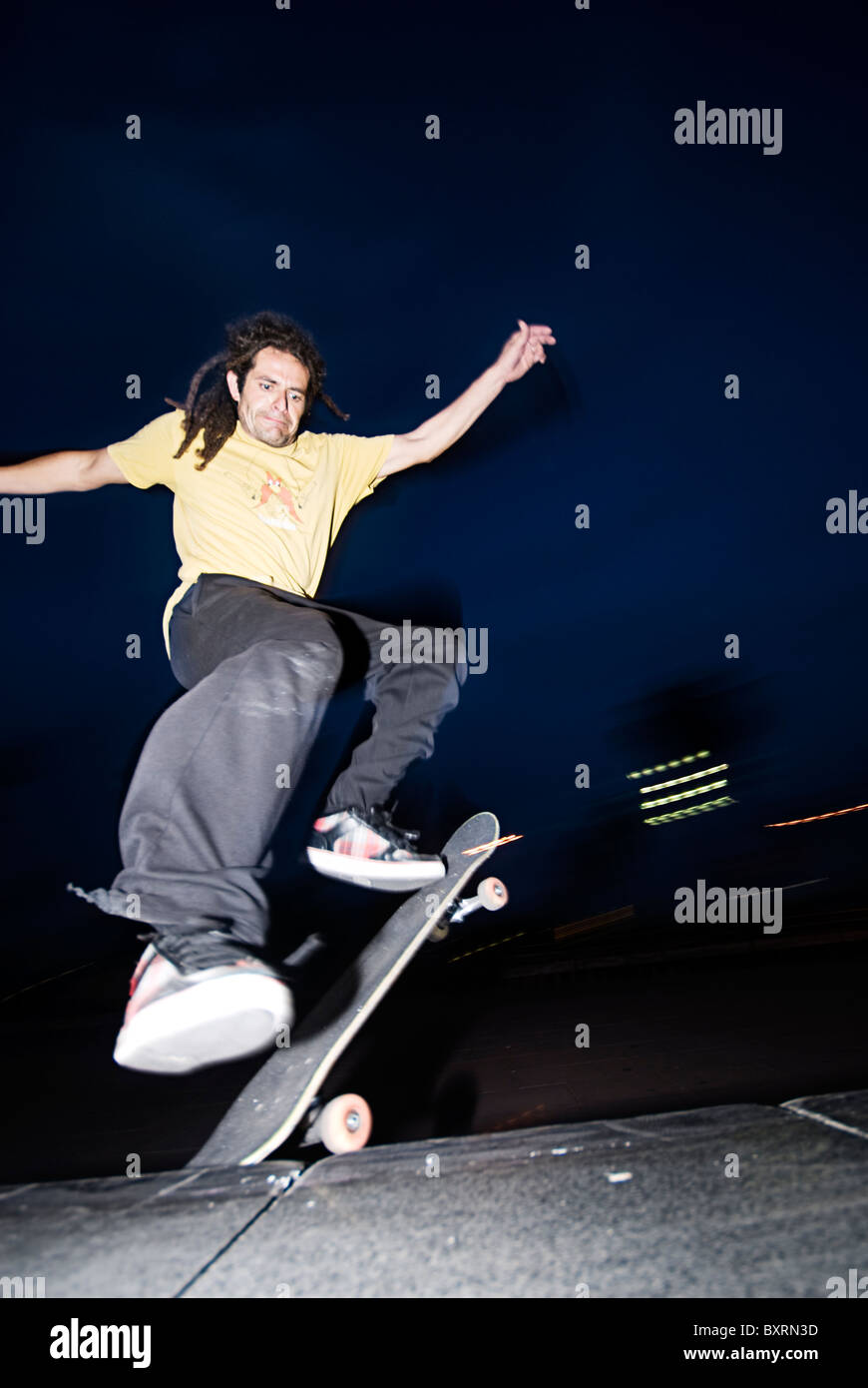young men skating and doing tricks, jumping for slide along an edge at