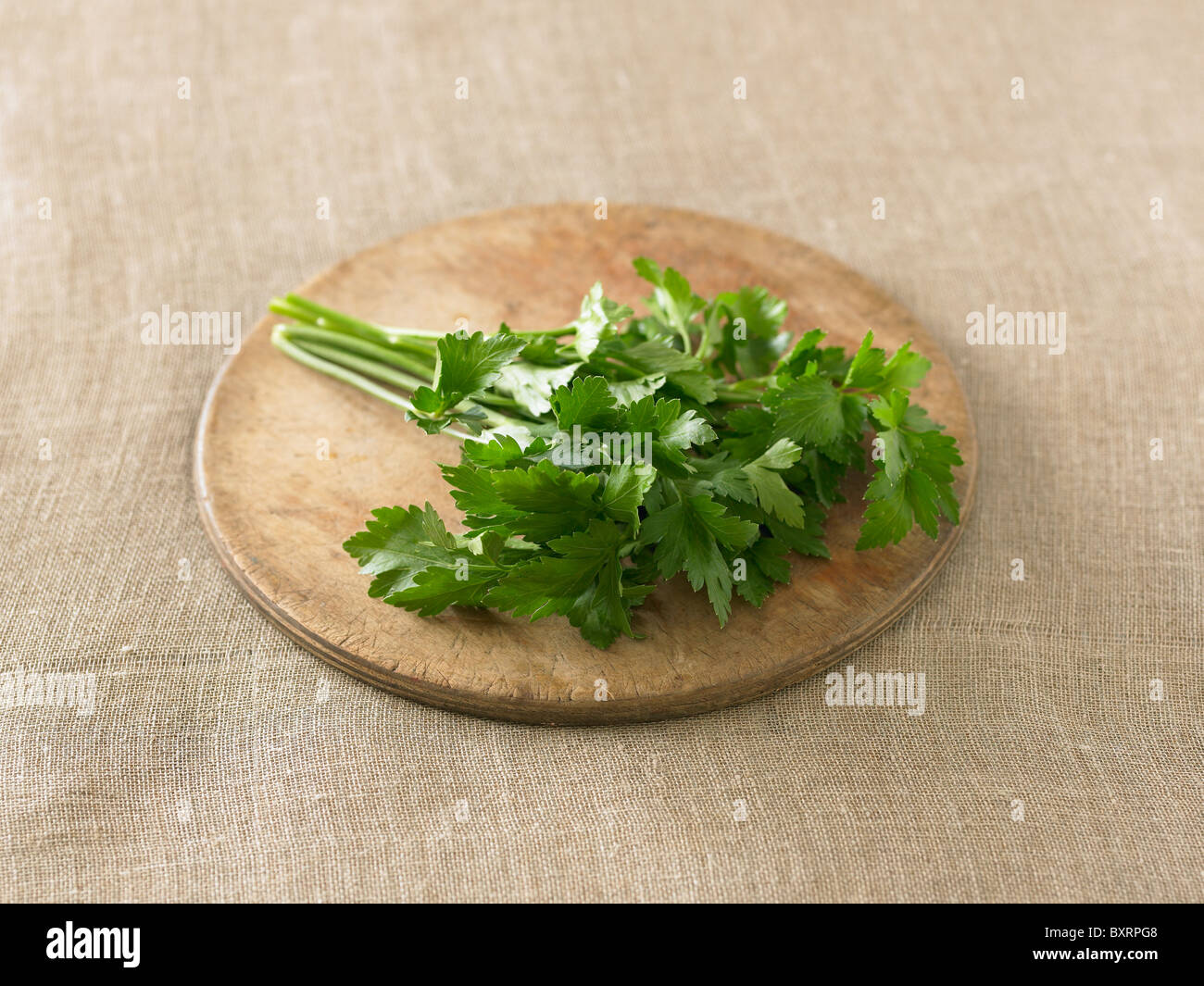 Flat leaf parsley on chopping board Stock Photo