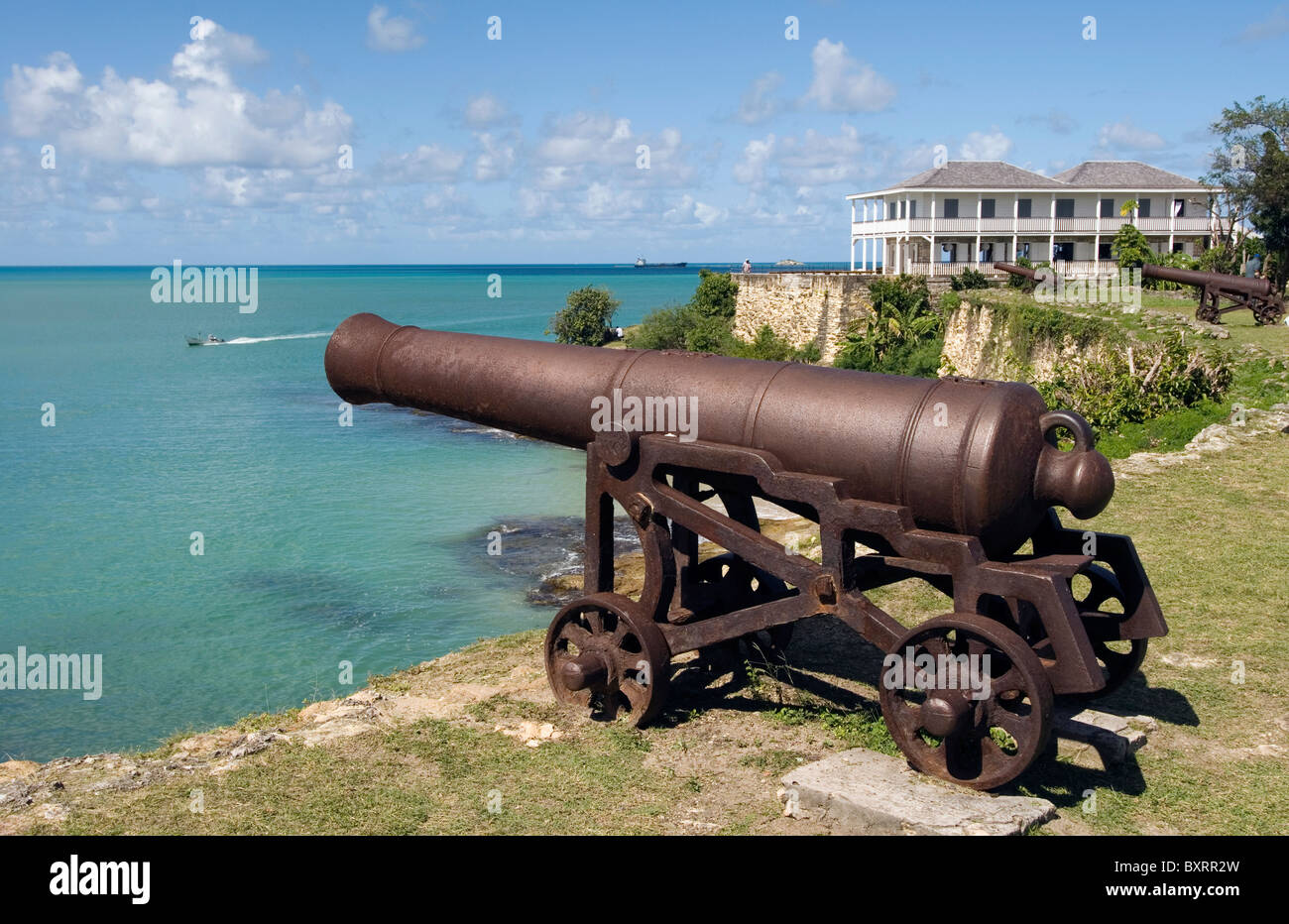 Caribbean, Leeward Islands, Antigua: St John's - Fort James, View of cannon on beach with fortress on background Stock Photo