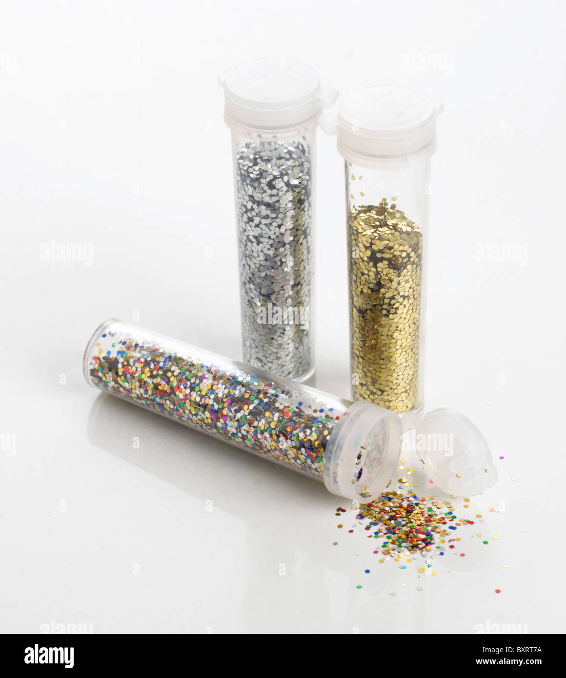 Coloured Glitter, Gold Glitter and Silver Glitter in plastic tubes. Stock Photo