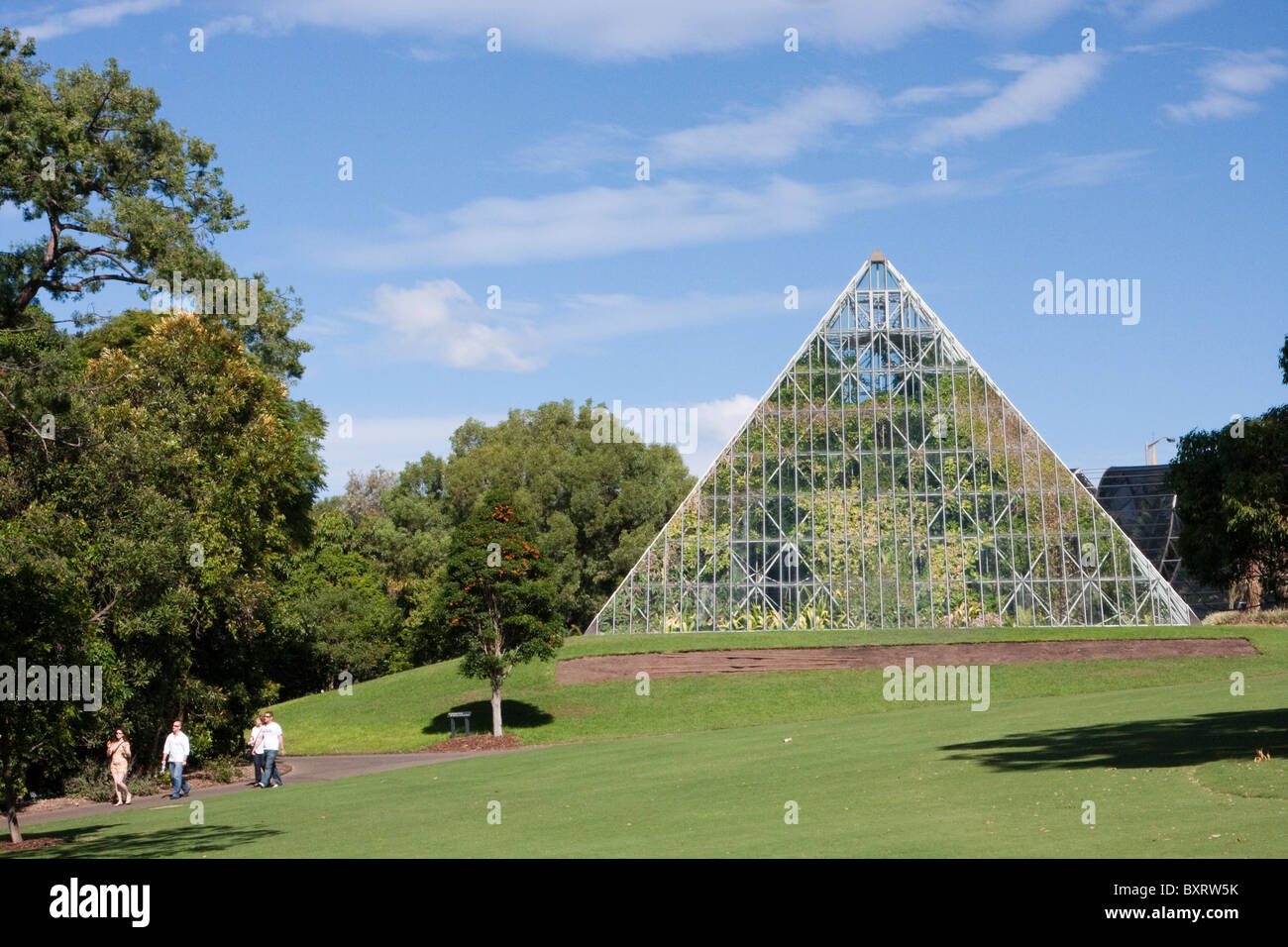 Australia, New South Wales, Sydney, Royal Botanic Gardens, People walking near pyramid shaped greenhouse Stock Photo