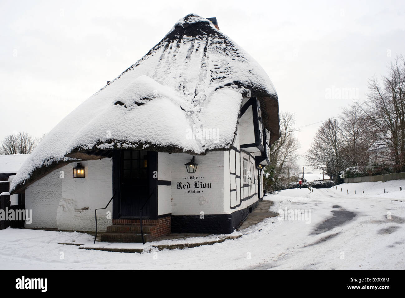 traditional thatched pub in the snow the red lion chalton hampshire england Stock Photo
