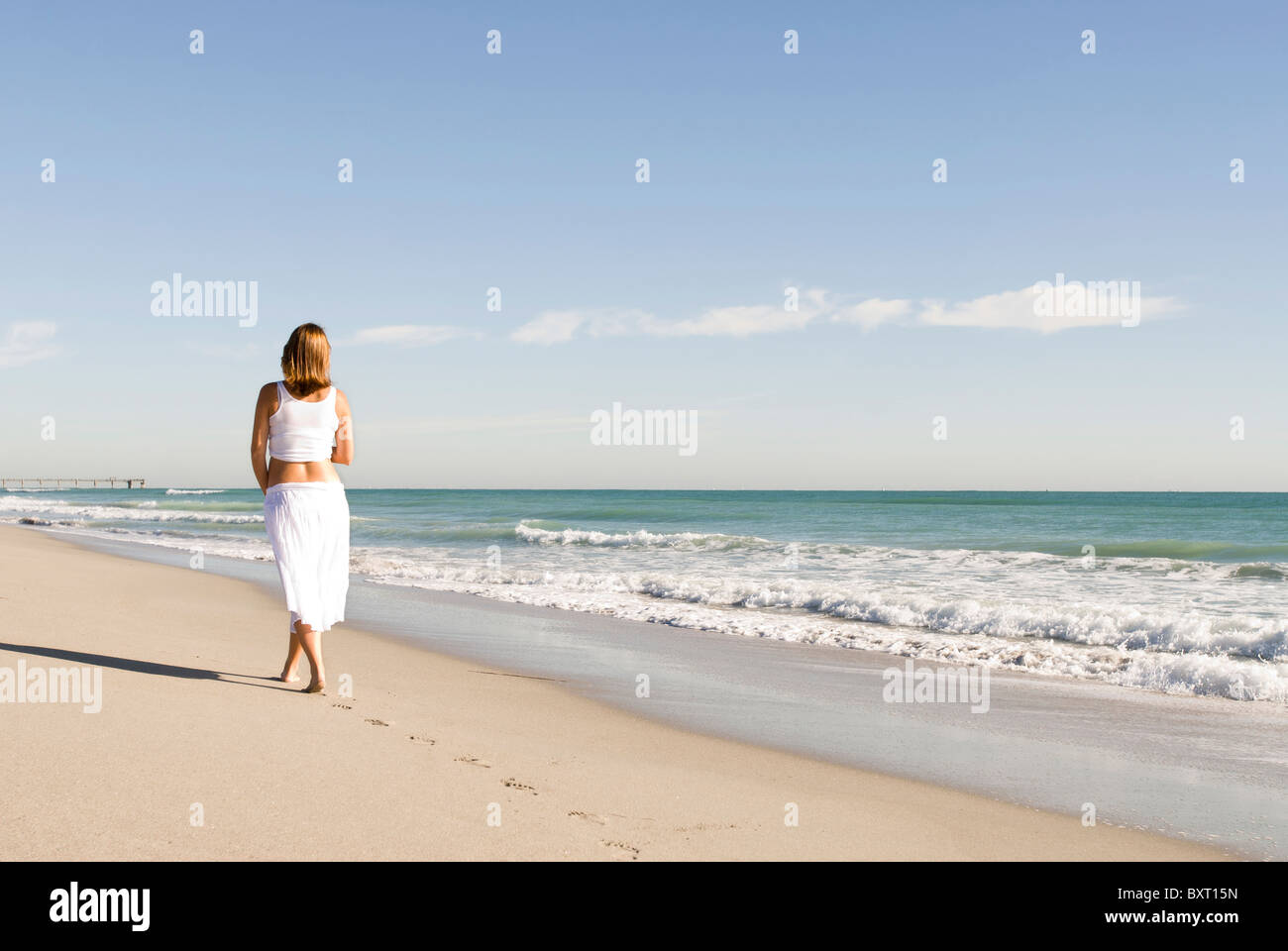 pregnant woman walking on beach Stock Photo