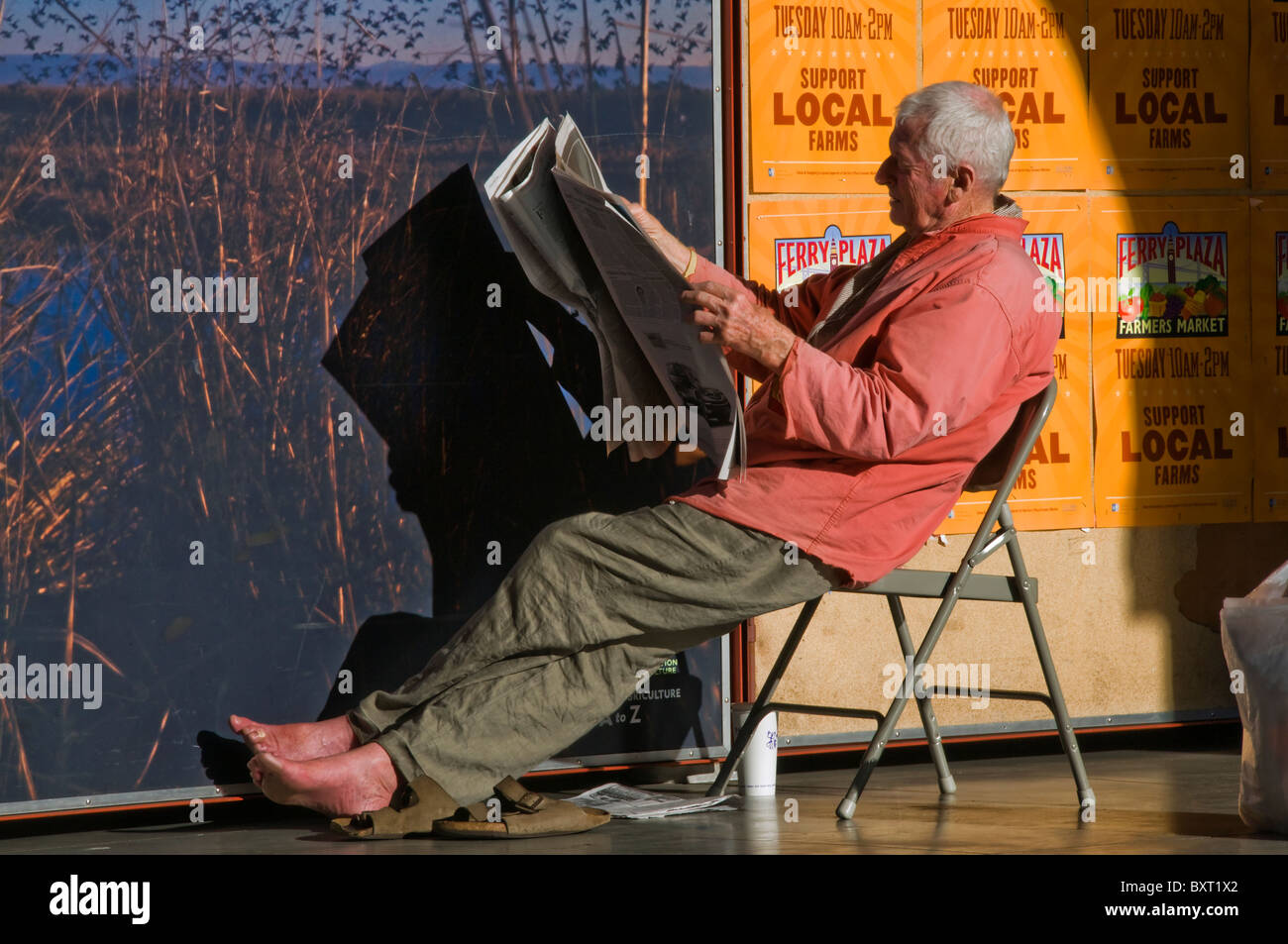 Elderly Senior Man Reading Newspaper On City Street In San