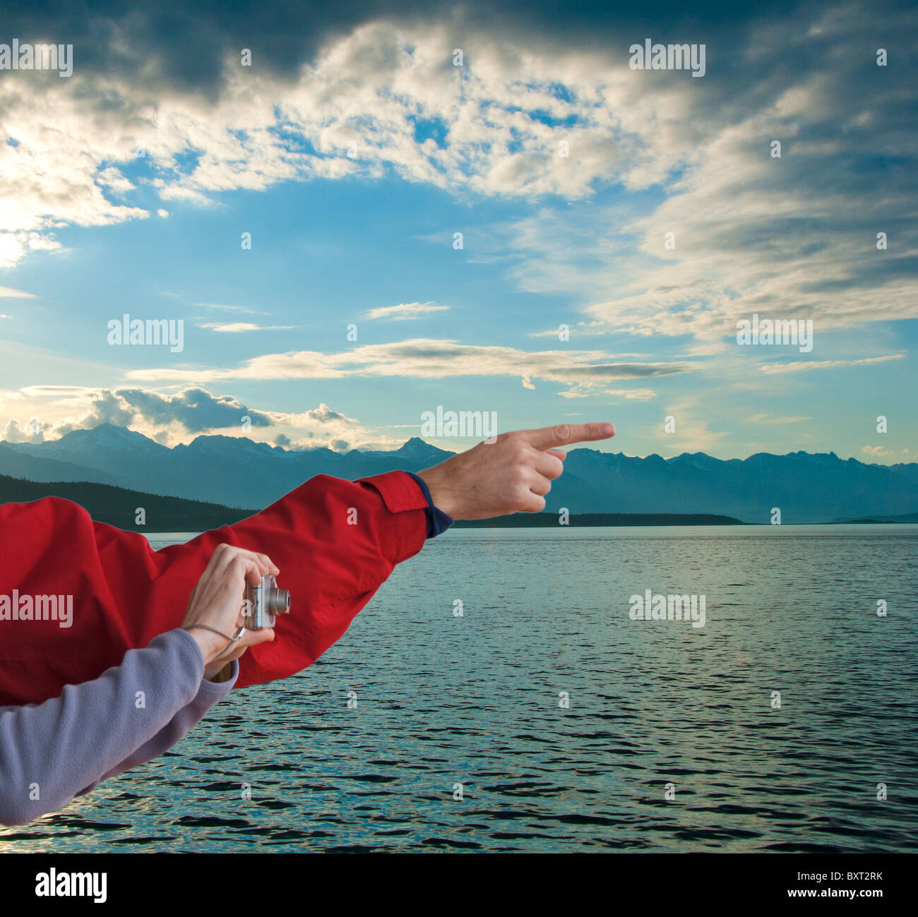 Man pointing and woman with digital camera in Inside Passage at dusk near Favorite Channel in Alaska Stock Photo