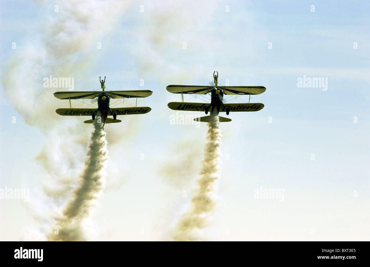 Two stunt biplanes with two wing-walking stunt performers (both girls) at an airshow. Stock Photo