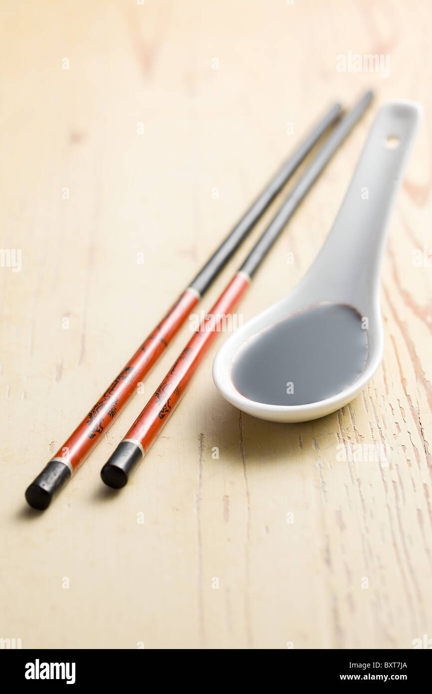 soy sauce and chopsticks on wooden table Stock Photo
